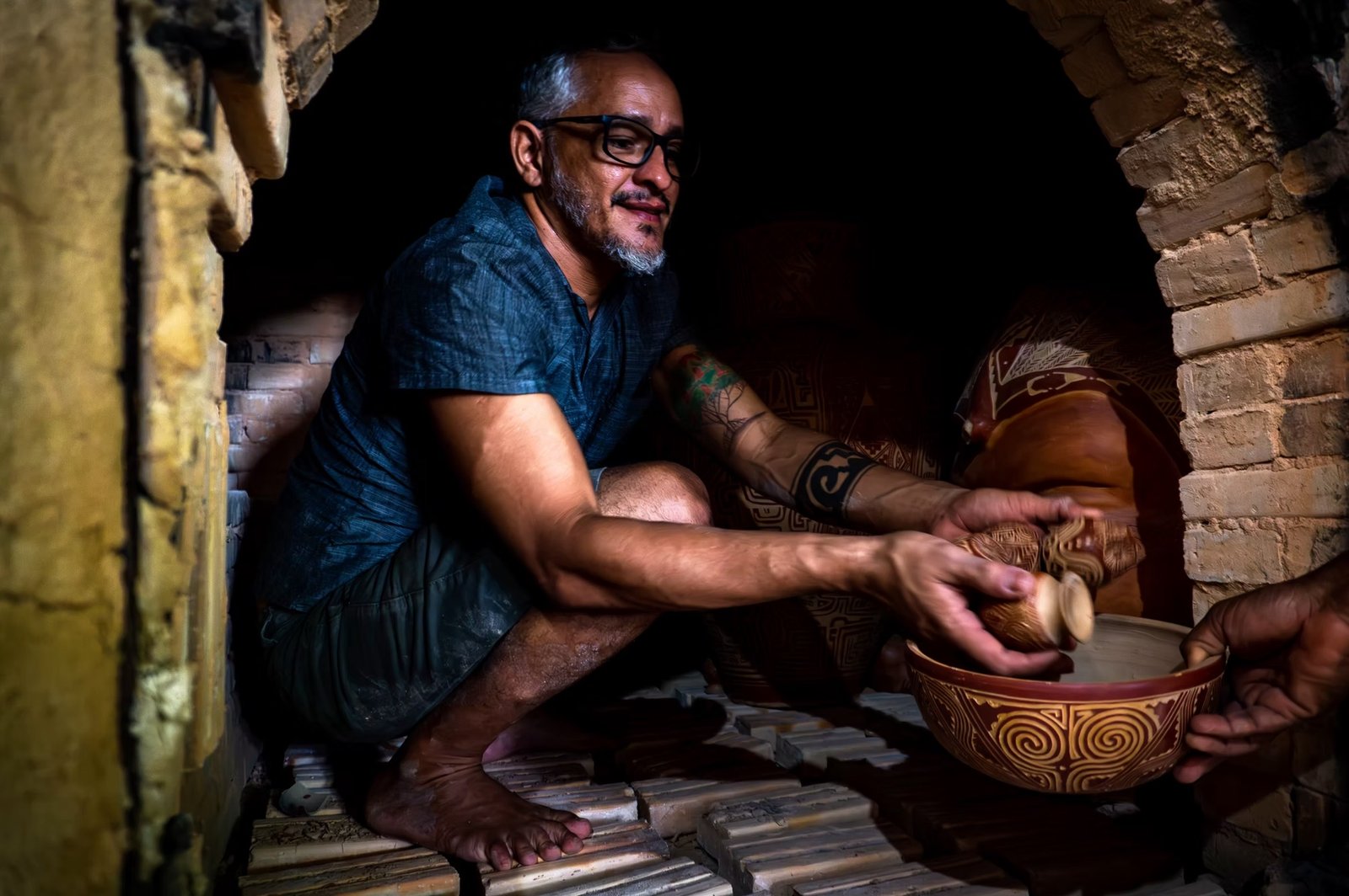Ronaldo Guedes recolhendo peças de cerâmica marajoara em abertura de forno.